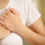 Woman holding her chest in pain