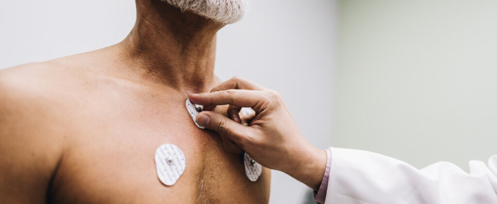 Close-up of human hands putting sensors of electrocardiography on a doctor's office
